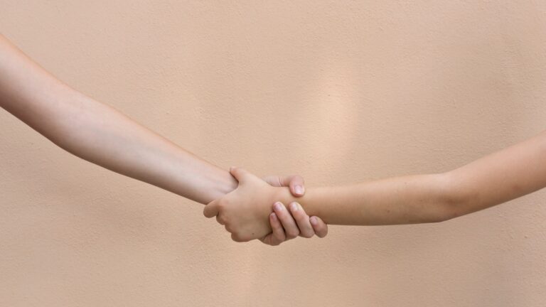 Help concept, two hands in front of an outdoors wall expressing some feelings.